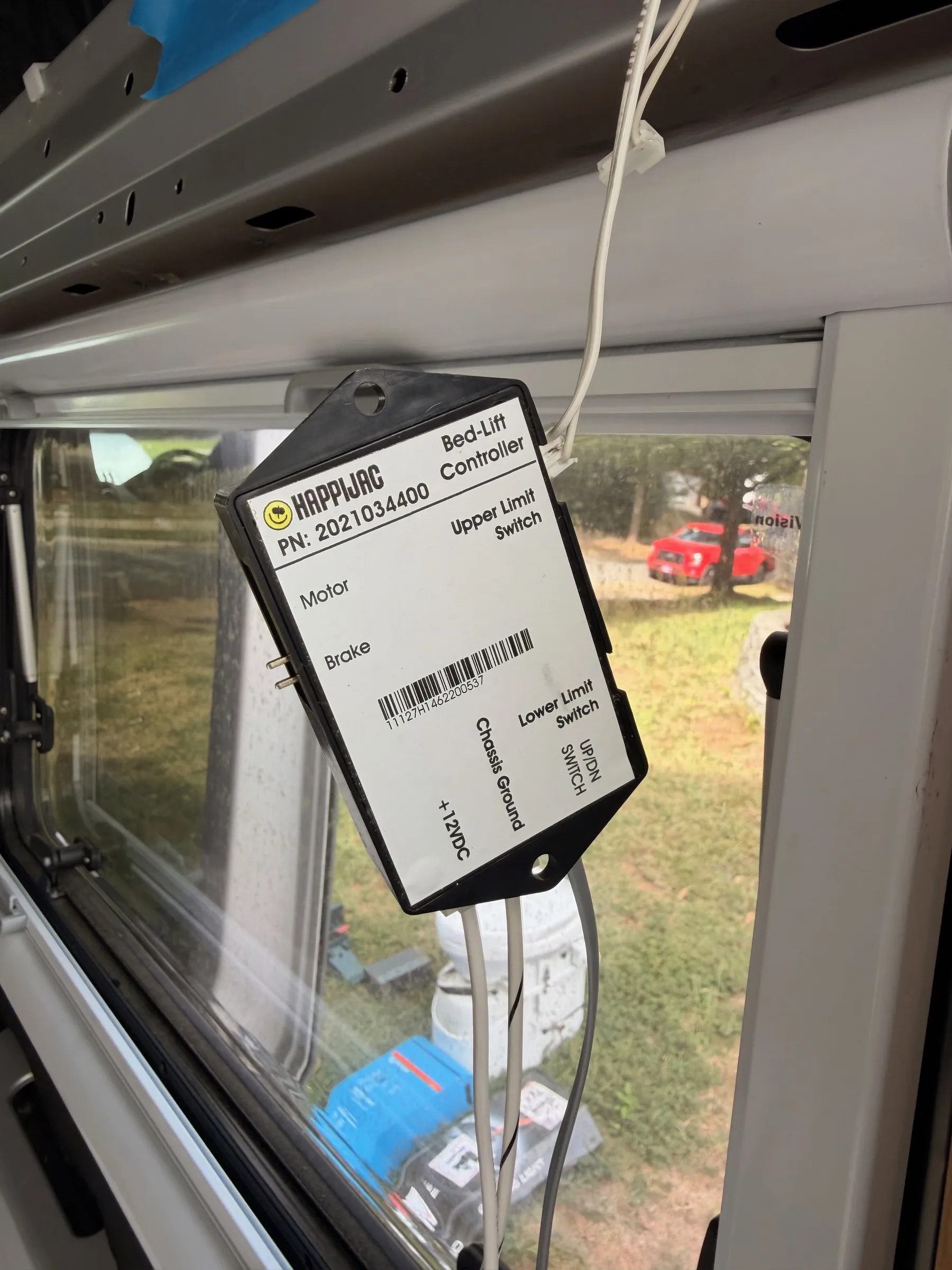 Happijac bed-lift controller box with wiring, hanging in front of a side window